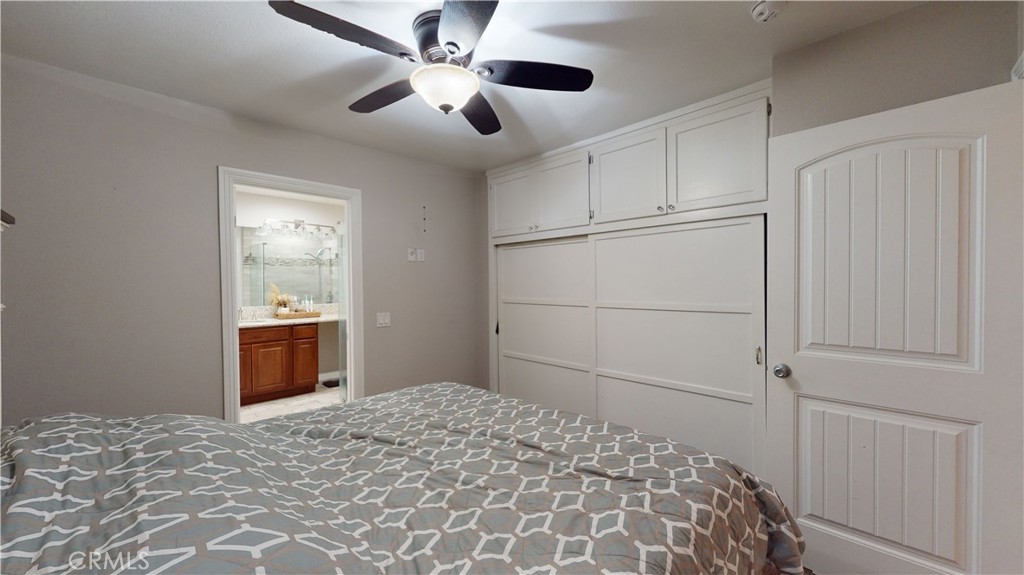 10039 Primrose Drive Riverside, CA 92503 - Photo 17 of 56 a bedroom with a large bed and a chandelier fan
