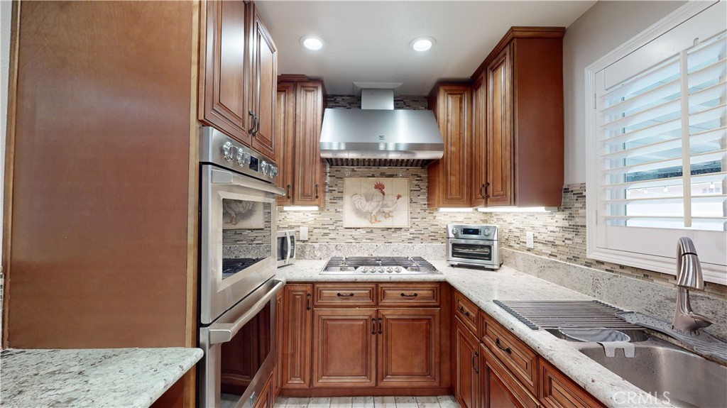 10039 Primrose Drive Riverside, CA 92503 - Photo 9 of 56 a kitchen with stainless steel appliances granite countertop a sink stove and cabinets
