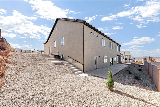 1491 East Centaurus Way, Unit 86 Washington, UT 84780 - Photo 22 of 26 View of side of home featuring stucco siding, stairs, and a fenced backyard