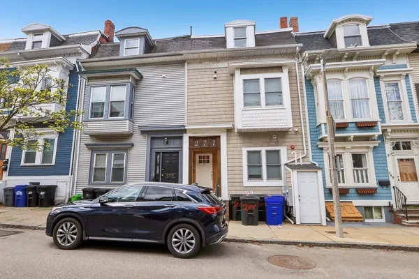 a car parked in front of a big house
