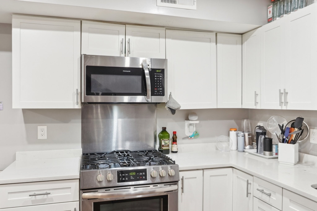 271 West Fifth Street Boston, MA 02127 - Photo 2 of 30 a kitchen with stainless steel appliances a white stove top oven and cabinets