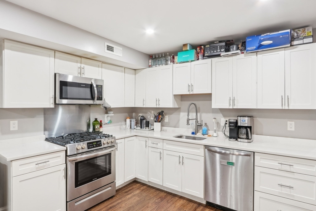 271 West Fifth Street Boston, MA 02127 - Photo 3 of 30 a kitchen with granite countertop white cabinets white stainless steel appliances and sink
