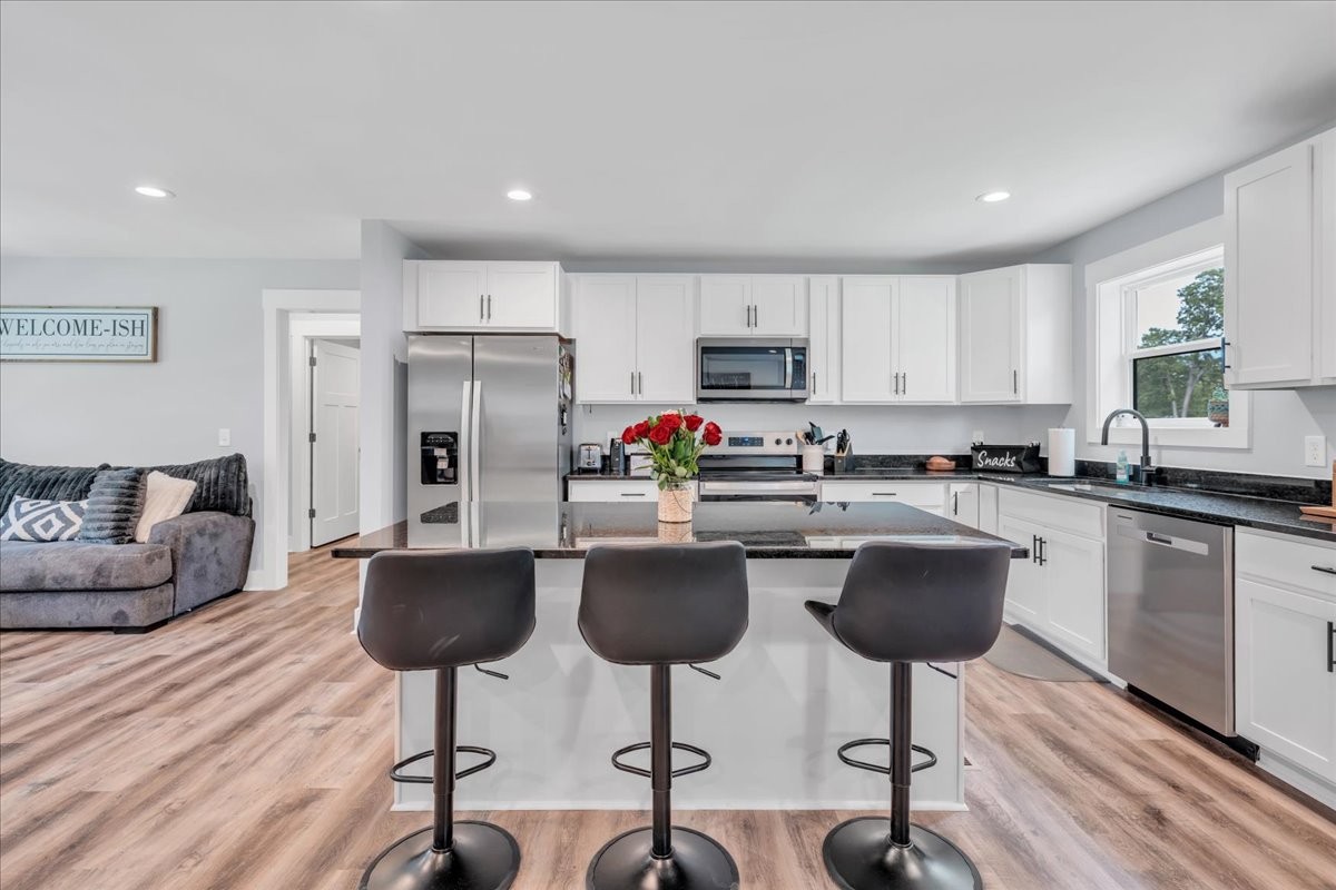 116 Carter Blake Road Tullahoma, TN 37388 - Photo 22 of 43 a kitchen with stainless steel appliances granite countertop a stove a sink a refrigerator a dining table and chairs with wooden floor