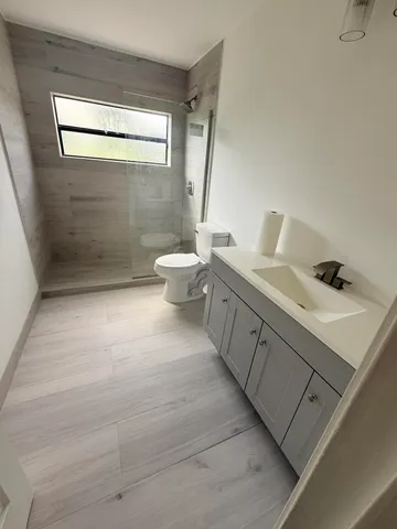 a bathroom with a double vanity sink toilet and shower