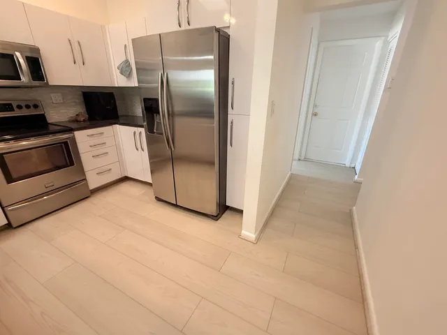 a kitchen with cabinets and stainless steel appliances