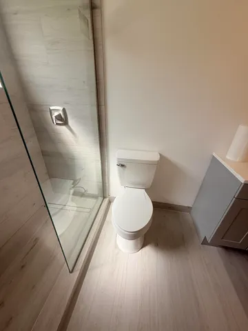 a bathroom with a toilet and a mirror
