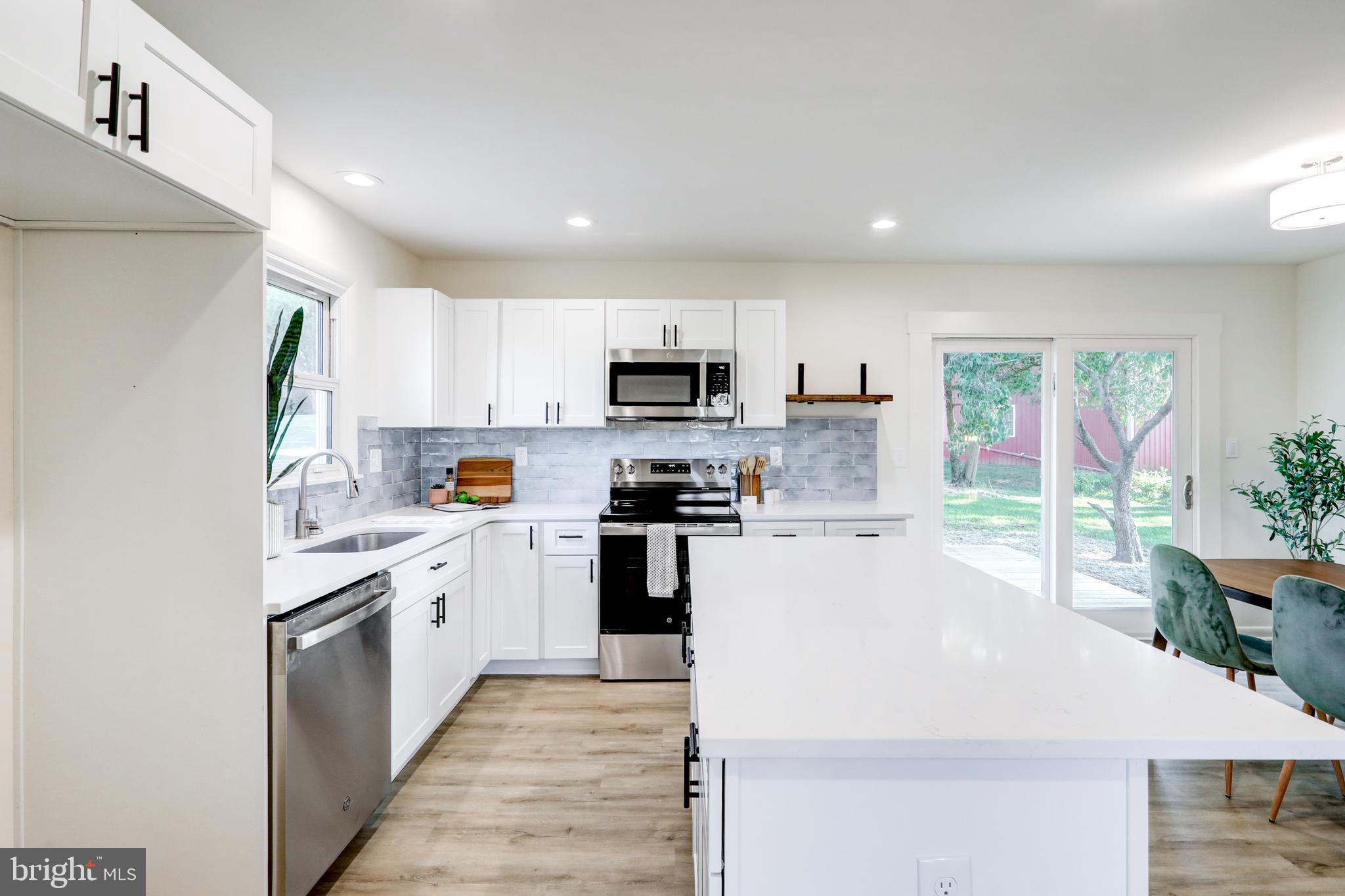 1198 Iron Bridge Road Columbia, PA 17512 - Photo 13 of 40 a kitchen with granite countertop a stove top oven a sink dishwasher and a refrigerator with wooden floor