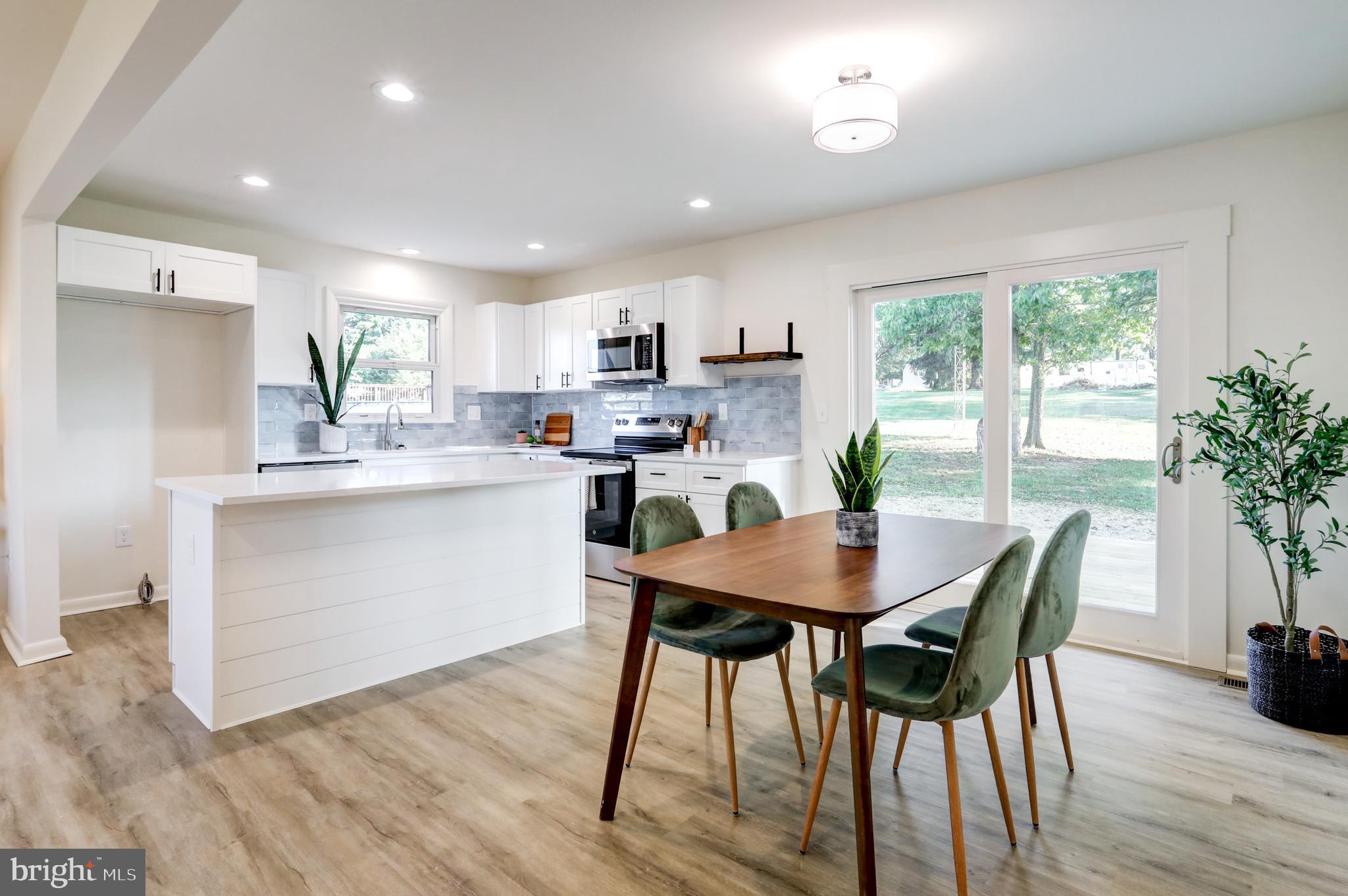 1198 Iron Bridge Road Columbia, PA 17512 - Photo 8 of 40 a kitchen with stainless steel appliances a dining table chairs and wooden floor