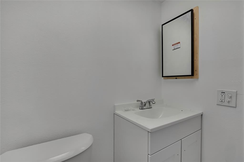 5242 Opal Lane, Unit 106 New Port Richey, FL 34652 - Photo 11 of 22 a bathroom with a toilet sink and mirror