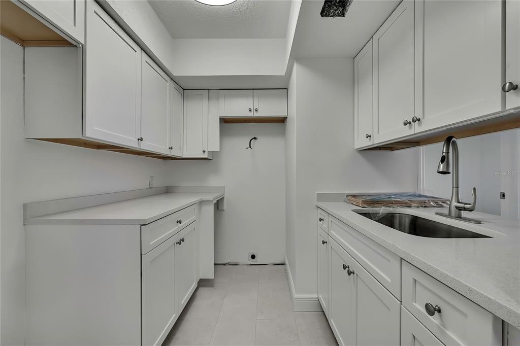 5242 Opal Lane, Unit 106 New Port Richey, FL 34652 - Photo 4 of 22 a kitchen with white cabinets and a sink