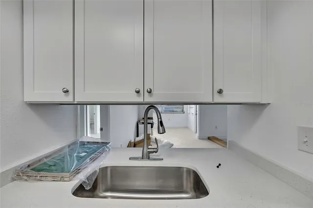 a kitchen with a sink and white cabinets