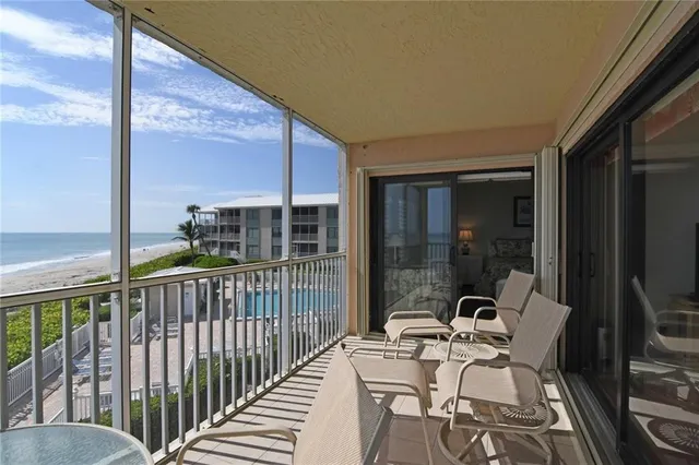 a balcony with chairs and a potted plant