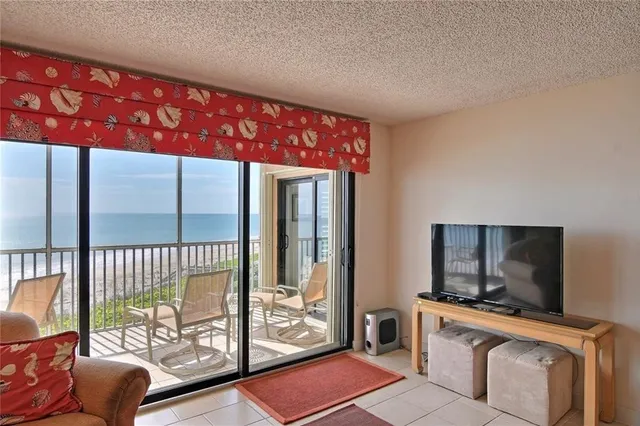 a living room with furniture a flat screen tv and a large window