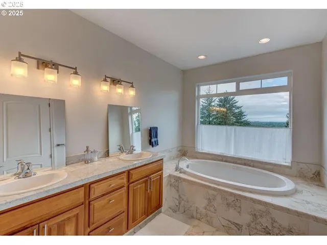 a bathroom with a tub sink and mirror