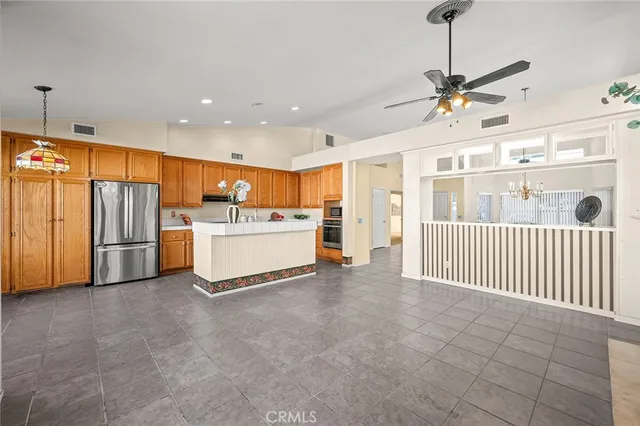 a view of a livingroom with furniture a ceiling fan and refrigerator