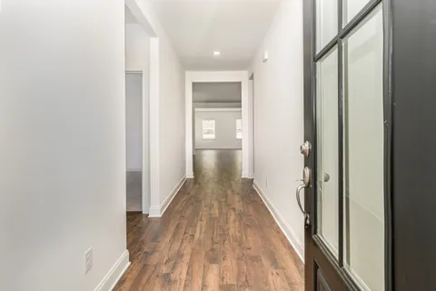 a view of a hallway with wooden floor