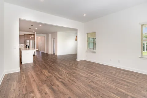 a view of a big room with wooden floor and a window