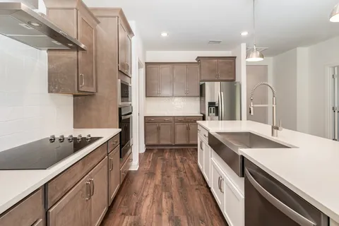 a kitchen with a sink stove top oven and refrigerator