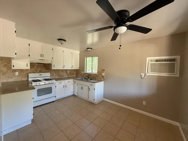 a kitchen with granite countertop cabinets a sink a window and stainless steel appliances