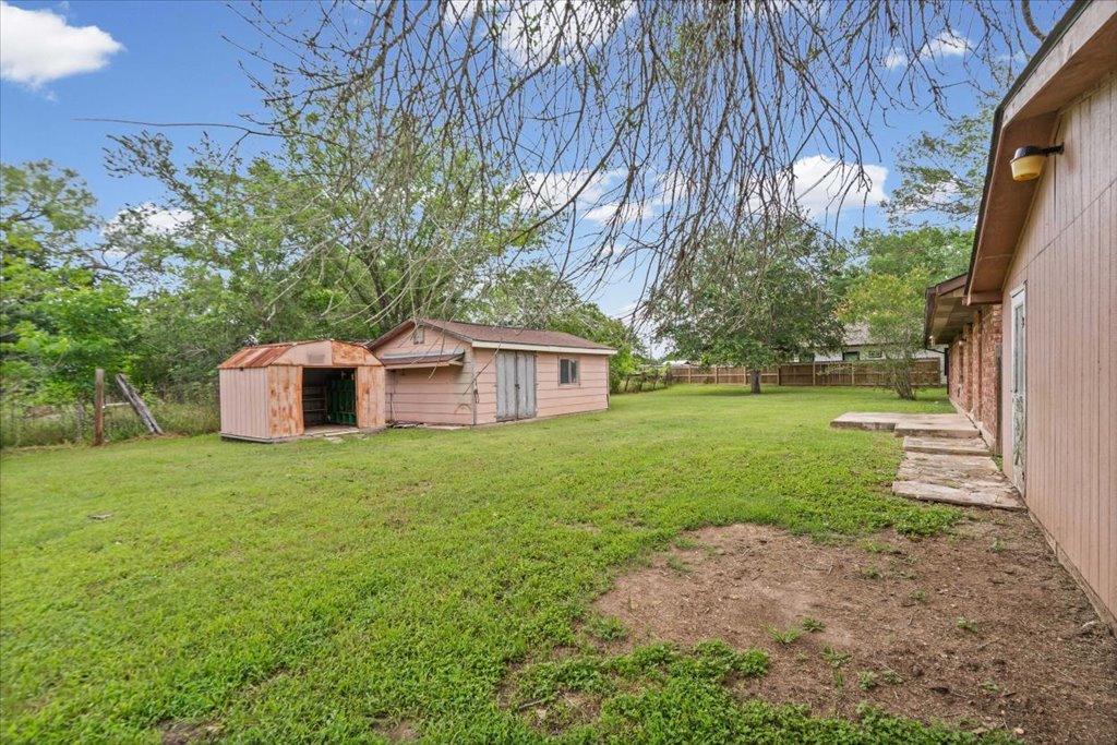 650 West Austin Street Luling, TX 78648 - Photo 16 of 18 A spacious backyard with two sheds and ample green space for outdoor activities.