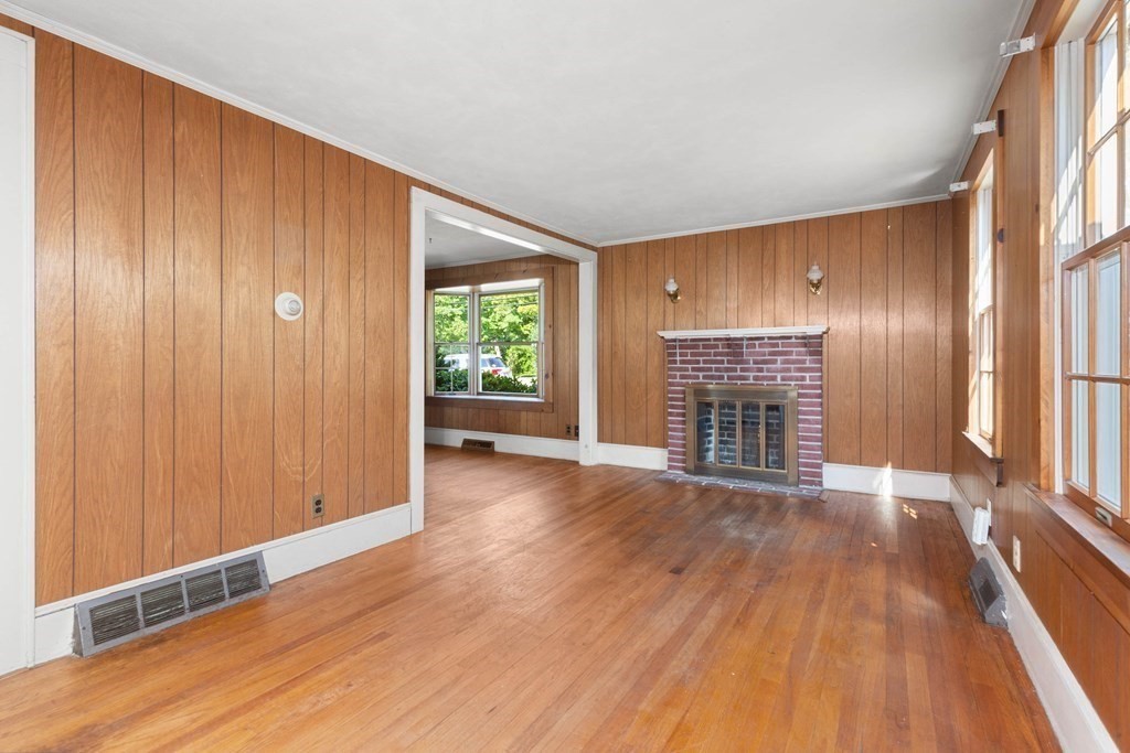 170 County Road Ipswich, MA 01938 - Photo 12 of 41 an empty room with wooden floor fireplace and windows