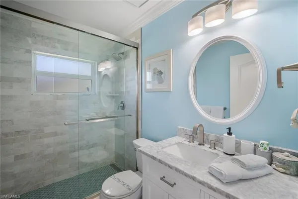 a bathroom with a granite countertop toilet sink and mirror