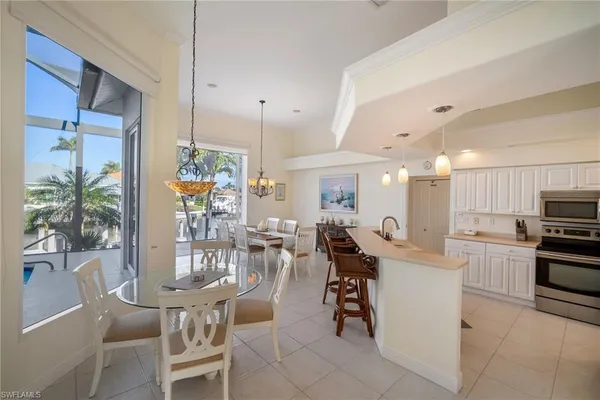 a kitchen with stainless steel appliances kitchen island granite countertop a table and chairs in it