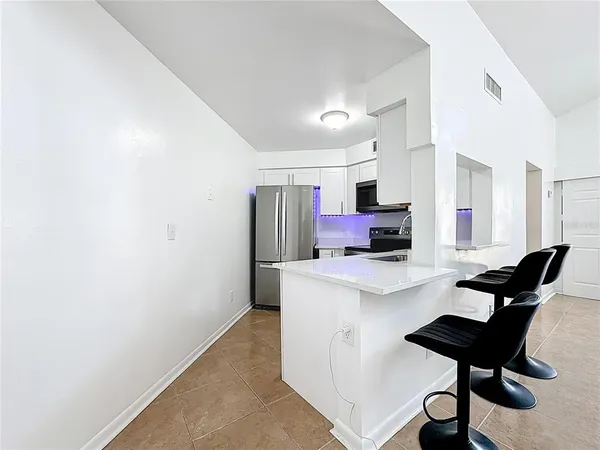 a kitchen with stainless steel appliances kitchen island a stove a sink and a refrigerator