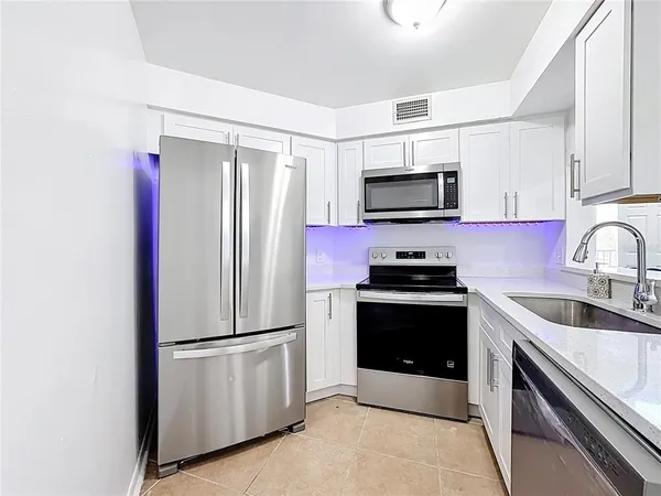 a kitchen with granite countertop a refrigerator and a sink