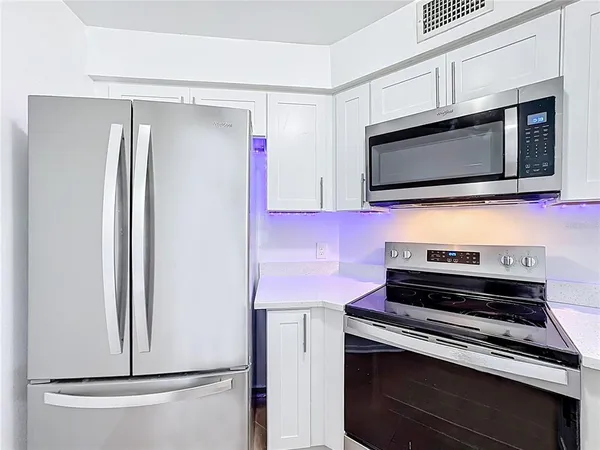 a kitchen with stainless steel appliances a stove microwave and refrigerator