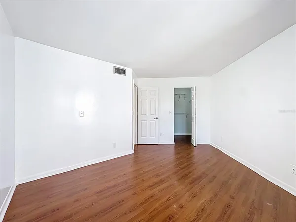 a view of an empty room with wooden floor