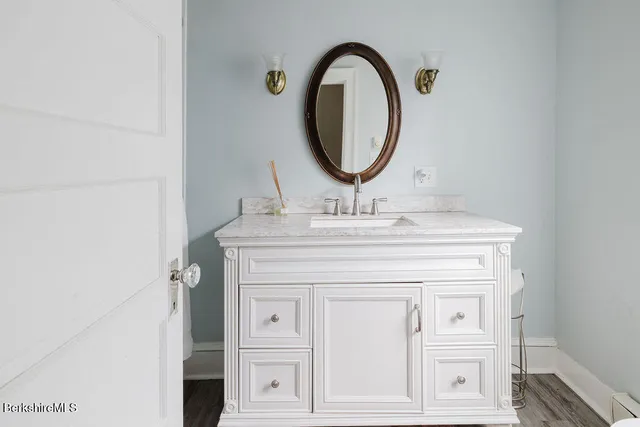 a bathroom with a granite countertop sink a mirror and a shower