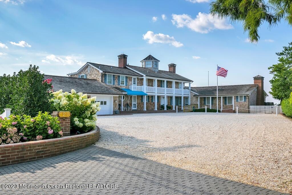 127 Curtis Point Drive Mantoloking, NJ 08738 - Photo 1 of 34 a front view of a house with a garden