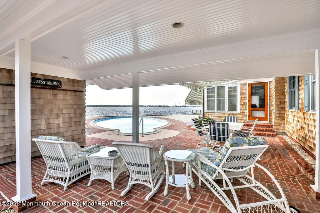 127 Curtis Point Drive Mantoloking, NJ 08738 - Photo 27 of 34 a view of a dining room with furniture large windows and wooden floor
