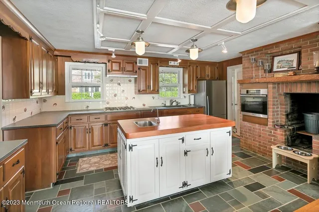 a kitchen with stainless steel appliances granite countertop a stove a sink and a refrigerator