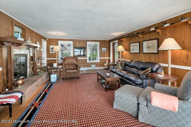 a living room with furniture a fireplace and a large window