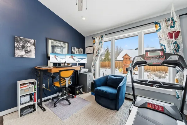 a view of a workspace with furniture and a window