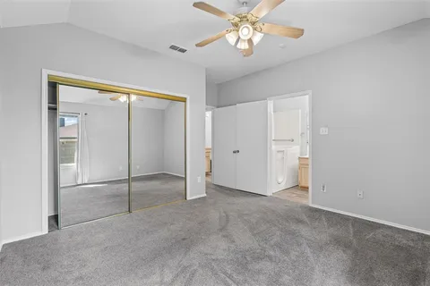 an empty room with closet and a chandelier fan