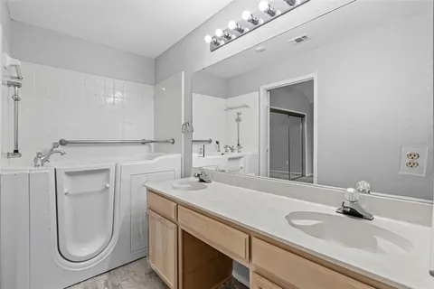 a bathroom with a granite countertop sink a mirror and vanity