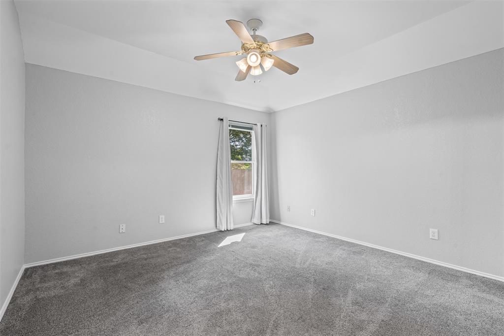 7301 Wagonwheel Road Fort Worth, TX 76133 - Photo 9 of 34 a view of an empty room with a ceiling fan and a window