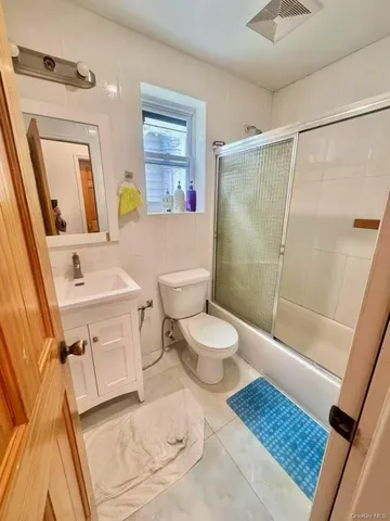 a bathroom with a toilet sink vanity tub and mirror