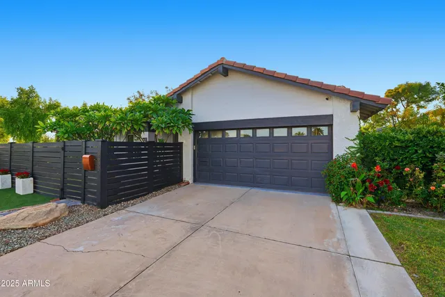 a view of house with garage and plants