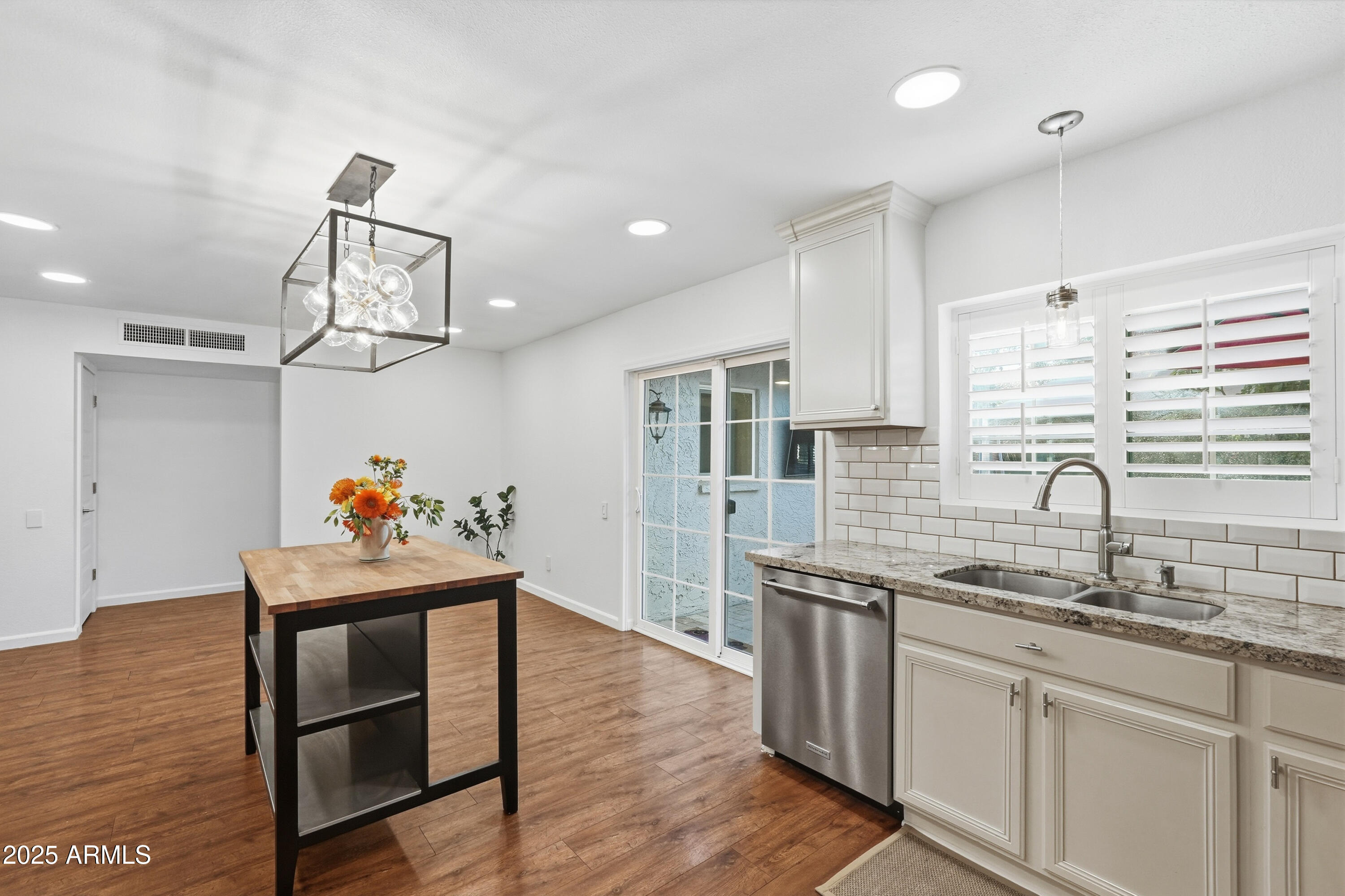 5632 South Jolly Roger Road Tempe, AZ 85283 - Photo 10 of 35 a kitchen with stainless steel appliances granite countertop a sink dishwasher and a dining table with wooden floor
