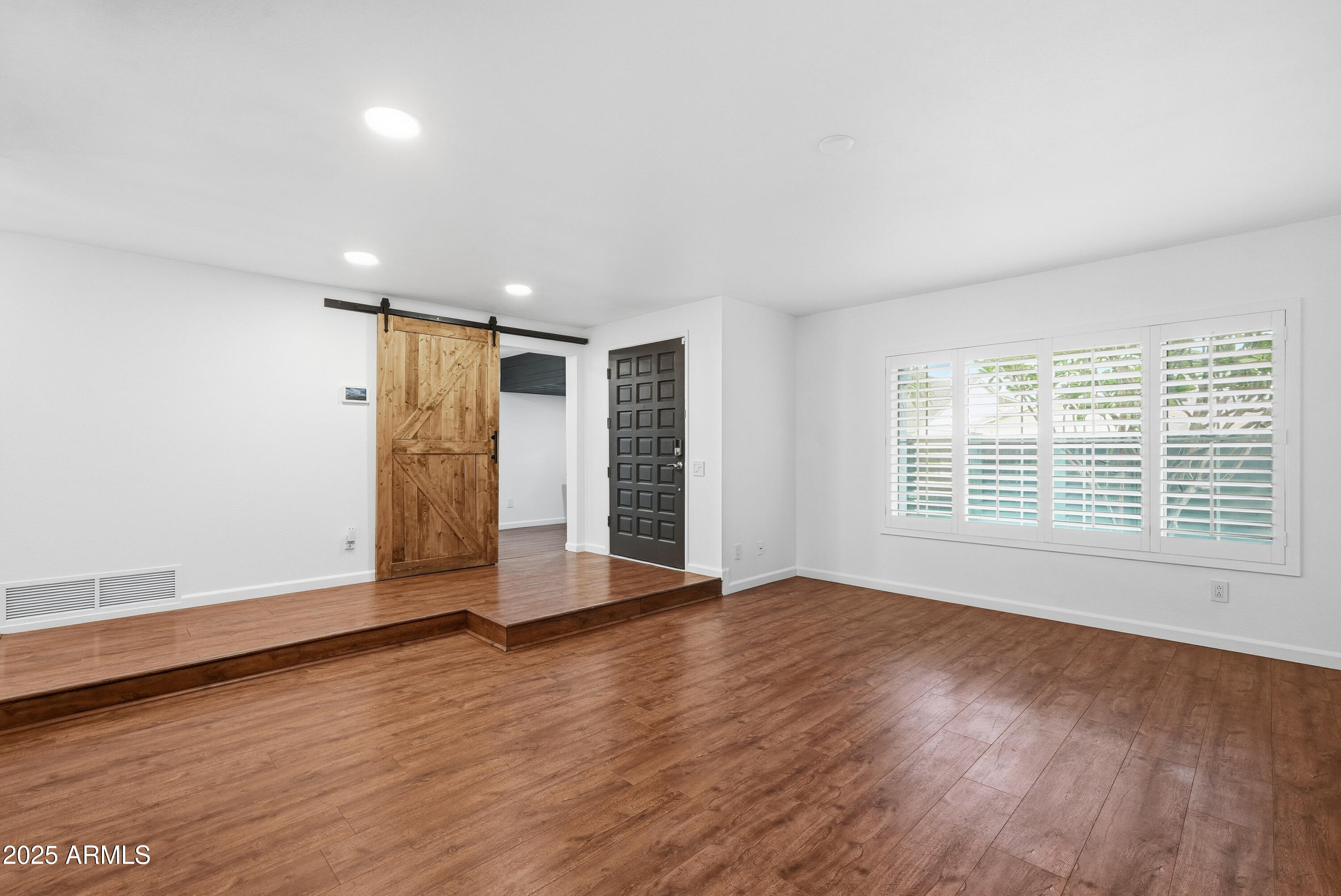 5632 South Jolly Roger Road Tempe, AZ 85283 - Photo 4 of 35 a view of an empty room with wooden floor and a window