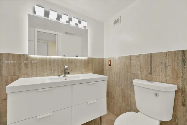 a bedroom with two beds and potted plant with two windows