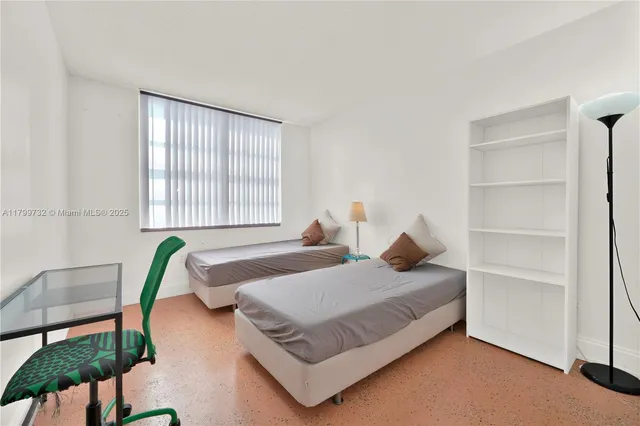 a bed sitting in a bedroom next to a window