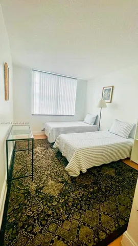 a view of a hallway with wooden floor and a living room