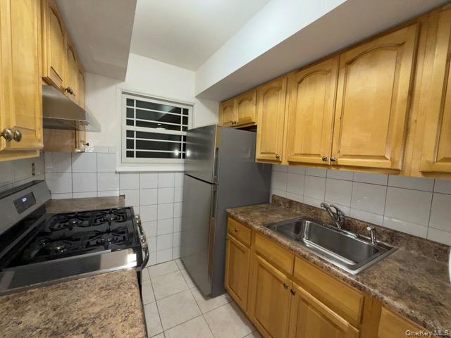 1020 Throggmorton Avenue, Unit 1 Bronx, NY 10465 - Photo 1 of 11 a kitchen with granite countertop a sink stove and refrigerator
