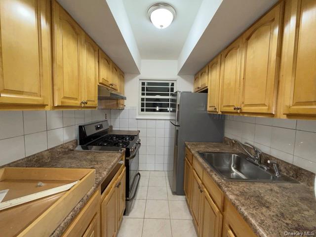 1020 Throggmorton Avenue, Unit 1 Bronx, NY 10465 - Photo 10 of 11 a kitchen that has a sink and a stove