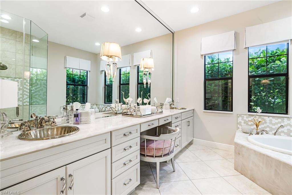 14480 Marsala Way Naples, FL 34109 - Photo 13 of 31 a bathroom with a double vanity sink large mirror and a bathtub